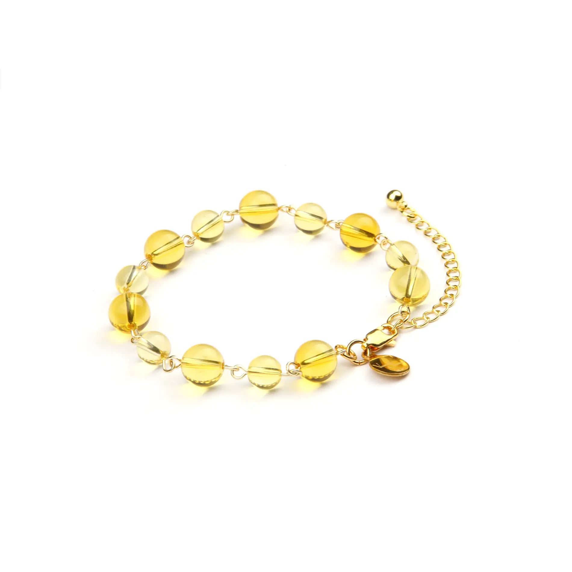 A gold chain bracelet featuring translucent yellow glass beads and a small gold heart charm, displayed on a clean white background.