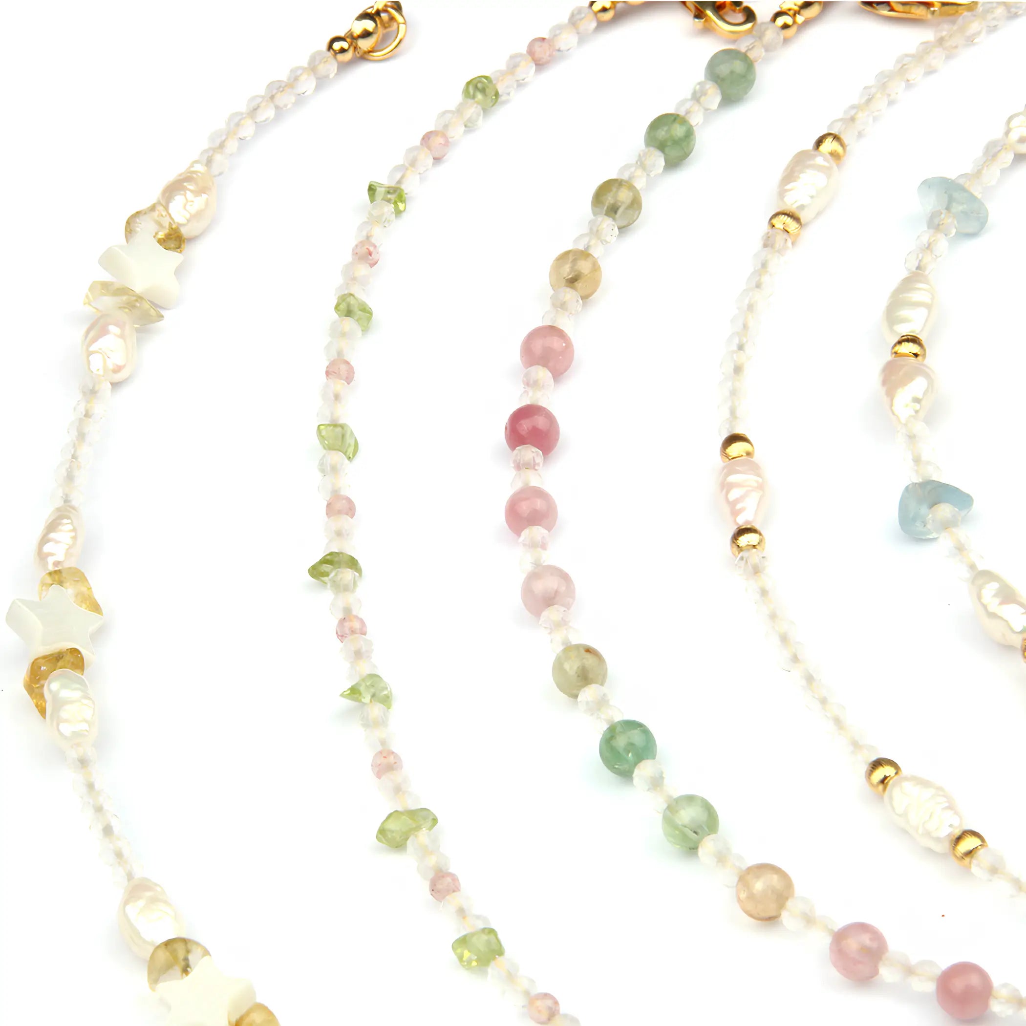Four beaded strands of jewelry laid out on a white background, featuring small translucent beads in pastel pink, green, blue, and cream, accented with gold-toned spacer beads and charms.