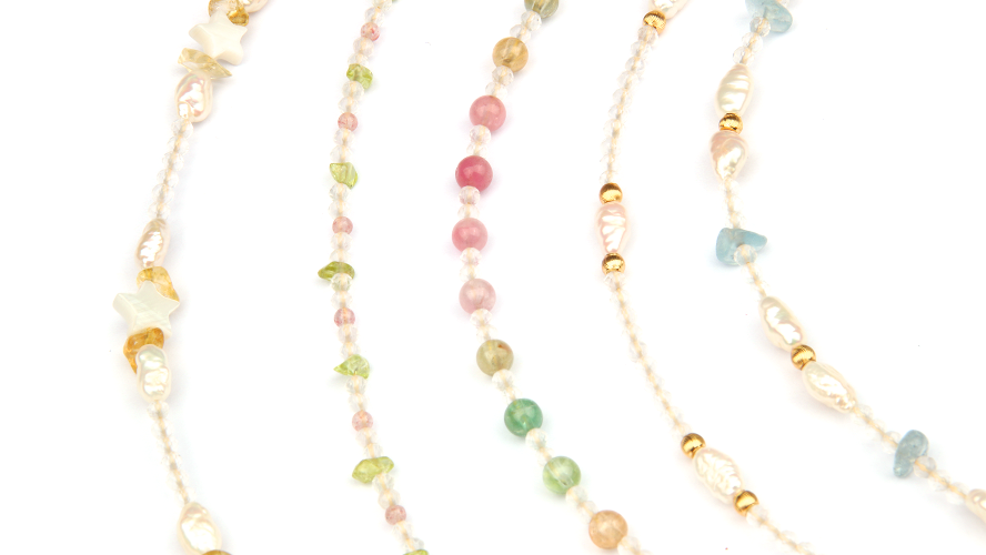 Set of three beaded necklaces with multicolored beads on a white background