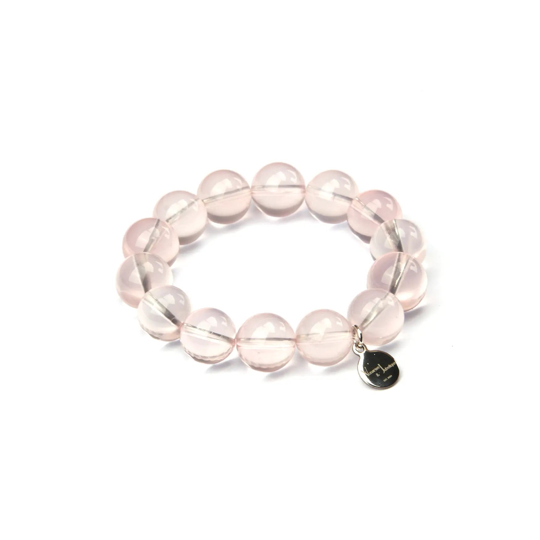 A beaded stretch bracelet made of translucent pale pink round beads with a small silver-tone heart charm, shown on a plain white background.