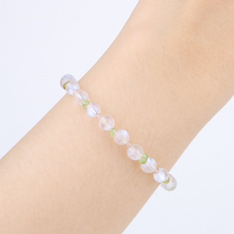 Delicate bracelet featuring blue moonstone, round strawberry rose quartz, and raw-shaped peridot in a minimalist design