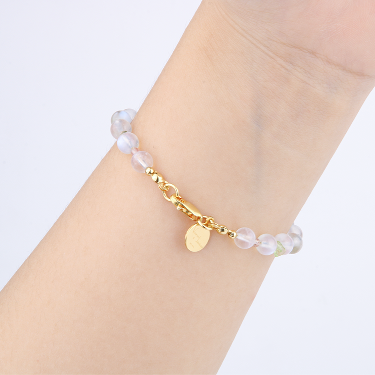 Delicate bracelet featuring blue moonstone, round strawberry rose quartz, and raw-shaped peridot in a minimalist design