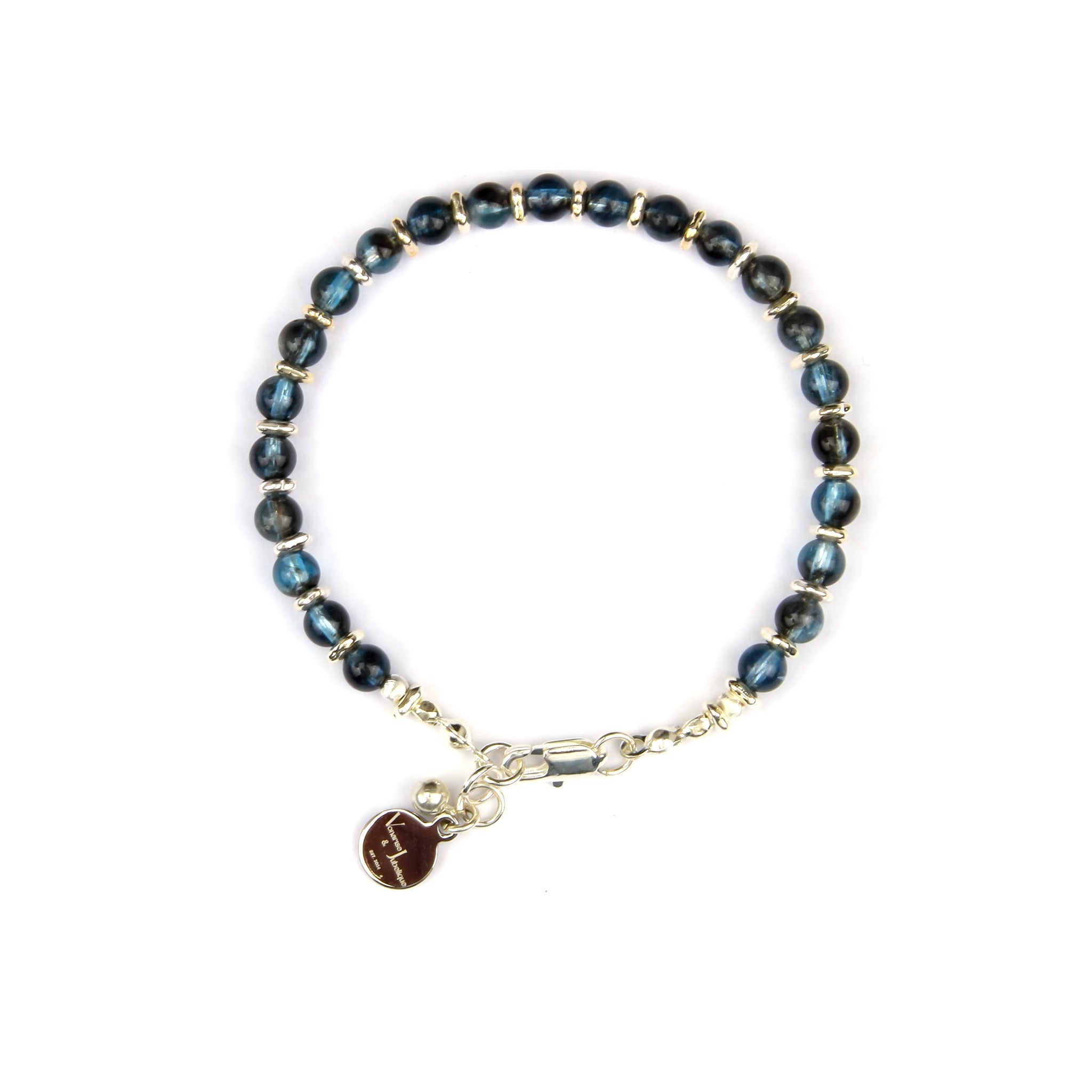 A beaded bracelet featuring dark blue labradorite beads separated by small gold spacer beads, with a gold clasp and a dangling gold charm engraved with the Libra zodiac symbol, shown on a plain white background.
