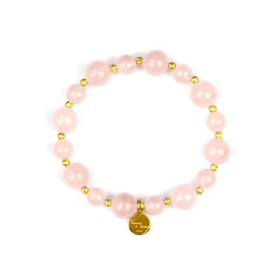 A pink beaded stretch bracelet featuring large round pink beads, small metallic gold spacer beads, and a gold circular charm at the bottom, displayed on a clean white background.